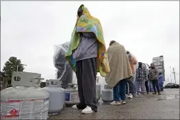  ?? DAVID J. PHILLIP — THE ASSOCIATED PRESS ?? Carlos Mandez waits in line to fill his propane tanks in Houston on Wednesday. Customers had to wait over an hour in the freezing rain to fill their tanks.