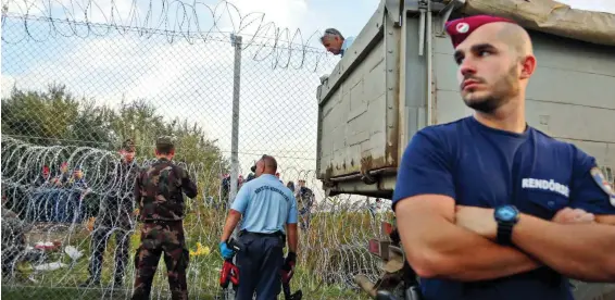  ?? FOT. BEATA ZAWRZEL/REPORTER ?? • 14 września 2015 r. Domykanie płotu na ostatnim dzikim przejściu pomiędzy Serbią a Węgrami. Dzień później Węgrzy wprowadzil­i karę więzienia za nielegalne przekrocze­nie granicy