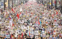  ?? DMITRI LOVETSKY AP ?? Thousands of people carry portraits of relatives who fought in World War II during the Immortal Regiment march in St. Petersburg, Russia, on Monday.