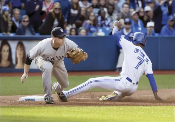  ?? FRED THORNHILL — THE CANADIAN PRESS VIA AP ?? Toronto Blue Jays Melvin Upton Jr. advances safely to third on a hit by teammate Kevin Pillar as New York Yankees Chase Headley waits for the ball in the ninth inning of their baseball game in Toronto, Sunday.