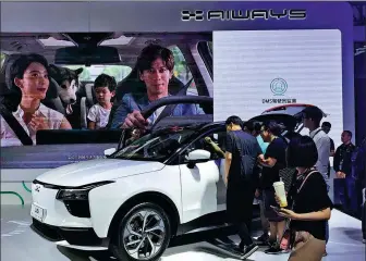  ?? LI FUSHENG / CHINA DAILY ?? Visitors examine an Aiways electric car at the 2019 CES Asia held in Shanghai.