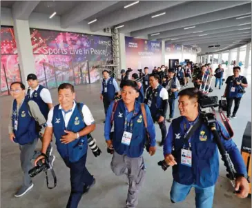  ?? HONG MENEA ?? Journalist­s cover the 32nd SEA Games at the Morodok Techo National Stadium in May.