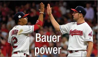  ?? AP PHOTO/PHIL LONG ?? Cleveland Indians' Francisco Lindor, left, congratula­tes starting pitcher Trevor Bauer before Bauer left in the seventh inning of Game 1 of a baseball American League Division Series, against the New York Yankees on Thursday in Cleveland. Bauer pitched...