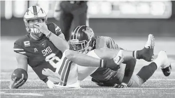  ?? ASHLEY LANDIS/AP ?? A penalty flag flies after SMU quarterbac­k Ben Hicks (8) was pulled down by his facemask by Memphis linebacker Curtis Akins on Friday night in Dallas.