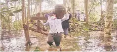  ??  ?? Villagers carry the ‘tajau’ – containing ancestral bones – away from the inundated site, in this 2012 photo.