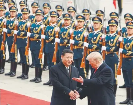  ?? Andrew Harnik, Associated Press file ?? Chinese President Xi Jinping welcomes President Donald Trump in November at the Great Hall of the People in Beijing. Trump seemed impressed with the pageantry but is nearing the end of his first year in office without hosting a state dinner.
