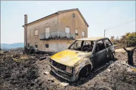  ?? Sergio Azenha The Associated Press ?? A burned-out car near Roda, Portugal, on Tuesday demonstrat­es the destructiv­eness of a huge wildfire that raged for four days and injured 39 people.