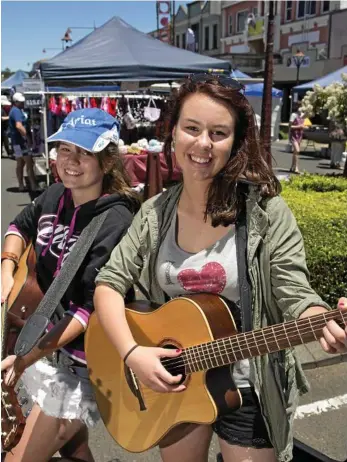  ?? PHOTO: KEVIN FARMER ?? PLAYING MUSIC: Sarah Lamshed (left) and Rhianna McKechnie busk at the Margaret Street Markets.