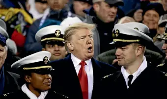  ?? AP ?? President Donald Trump stands in the seating along the Navy sidelines before the second half of a NCAA college football game between Army and Navy. The trip offered a distractio­n to the president’s growing legal difficulti­es.