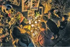  ?? ?? ABOVE: Family members and friends gather Friday to hold a candleligh­t vigil for Shirley Reyes, who was killed inside her home in Taos.