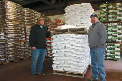  ?? Mona Weatherly ?? Companies like Evans Feed of Broken Bow are ready to help farmers and ranchers take on any challenges 2021 may toss their way. Above, Mike Evans, owner of Evans Feed, right, and Travis Sterner, distiller broker, stand next to pallets of feed in one of the company’s warehouses.