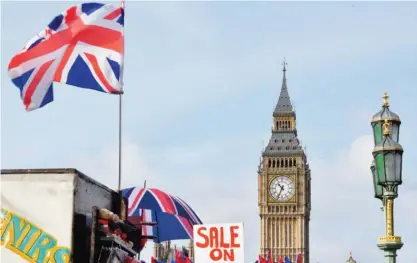  ??  ?? LONDON: A Union flag and a sign reading ‘Sale on’ are pictured near the Elizabeth Tower, better known as ‘Big Ben’, and the Houses of Parliament in central London yesterday. — AFP