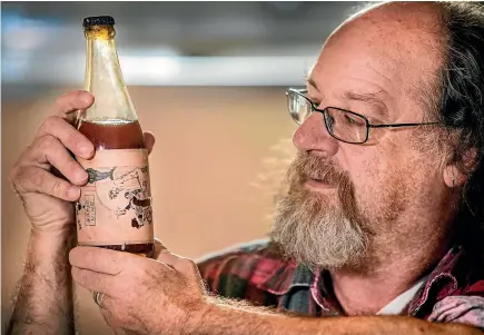  ?? PHOTOS: ANDY JACKSON/FAIRFAX NZ ?? Kim Mallowes, from New Plymouth, has found an old bottle of grape wine which he thinks dates back to around 1966.