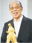  ??  ?? Nakajima speaking behind a gold statue of Godzilla at a Godzilla exhibition in Tokyo on July 19, 2014. — AFP photo