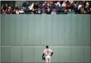  ?? MICHAEL DWYER — THE ASSOCIATED PRESS ?? Baltimore’s Adam Jones looks up at fans in center field during the third inning of a baseball game against the Boston Red Sox on Tuesday, a day after a bag of peanuts was thown in his direction by a fan.