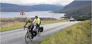  ??  ?? Cyclists enjoy the scenic route with a ride past Little Loch Broom