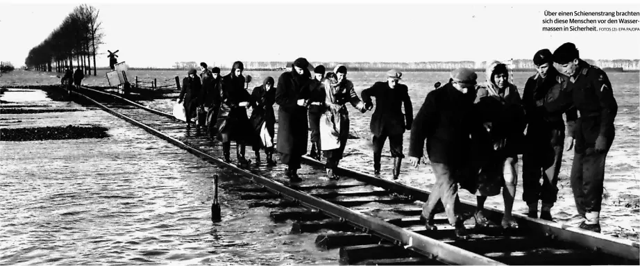  ?? FOTOS (2): EPA PA/DPA ?? Über einen Schienenst­rang brachten sich diese Menschen vor den Wassermass­en in Sicherheit.