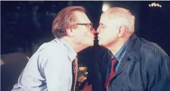  ??  ?? ABOVE: Larry King and Marlon Brando pucker up in 1997. They shared a famous kiss during a 1994 interview.