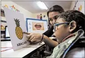  ?? ERALDO PERES/AP ?? Maria de Fatima Santos helps son Joaquim, 18 months, at school May 8 in Brazil. He was born with microcepha­ly.