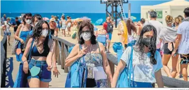  ?? JULIO GONZÁLEZ ?? Personas con mascarilla entran o salen por un acceso a la playa de La Fontanilla en Conil de la Frontera.