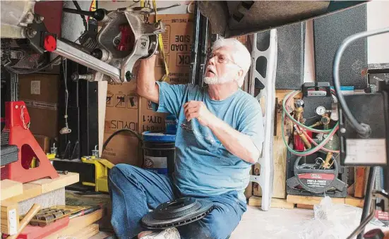  ?? Photos by Kirk Sides/Staff photograph­er ?? Gary Wingfeld tightens a bolt on a wheel assembly on his vintage 1994 C4 Corvette. He was able to return to his favorite pastime, restoring cars, after his surgery.