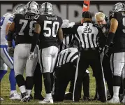  ?? ERIC RISBERG / ASSOCIATED PRESS ?? Cowboys offensive players and Raiders defensive players await the ruling of a crucial fourth-down measuremen­t that went the Cowboys’ way.