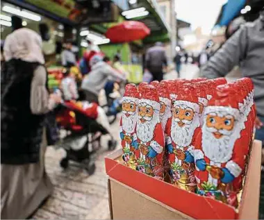  ?? Foto: AFP ?? In einer Gasse in der Jerusaleme­r Altstadt verkauft ein Händler Schoko-Nikoläuse.