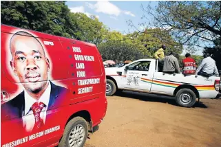  ?? /Reuters ?? New era for Zimbabwe: Members of the governing Zanu-PF wait outside an election nomination court in Harare, Zimbabwe, on June 14.