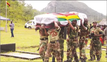  ??  ?? Zimbabwe National Army pallbearer­s carry a casket with the body of Cde Sigauke at the Manicaland Heroes Acre. (Picture by Tinai Nyadzayo)