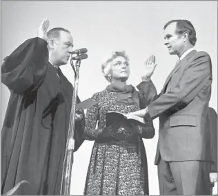  ?? Associated Press ?? ‘A GREAT CHAMPION OF THE AGENCY’ With his wife, Barbara, looking on, Bush is sworn in as the new director of the Central Intelligen­ce Agency by U.S. Supreme Court Justice Potter Stewart in 1976.