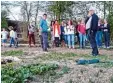  ?? Foto: Manfred Sailer ?? Jonas Machnik (Bildmitte) zeigt, wo als Projekt einer solidarisc­hen Landwirt schaft bei Hergertswi­esen das Gemüse angebaut wird.