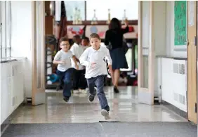  ??  ?? Students run to go outside at the start of recess at Little Fort Elementary school in Waukegan, Ill. Over the past five years, Waukegan District 60 lost $43 million in state aid because Illinois cut education funding.