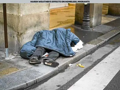  ?? —AFP ?? A homeless man sleeps on a street in central Paris as a cold wave hits much of Europe.