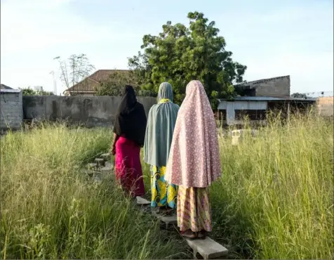  ?? Tom Saater/ Washington Post photos ?? Three young girls, including Fatima and Goggo, walk home in Maiduguri, Nigeria, on Sept. 4. They are among thousands of children detained in recent years by Nigerian armed forces amid a decadelong conflict that often turns victims into suspects.