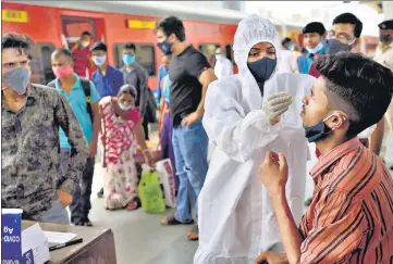  ??  ?? A healthcare worker collects swab samples of passengers arriving from outstation trains at Dadar station on Thursday.