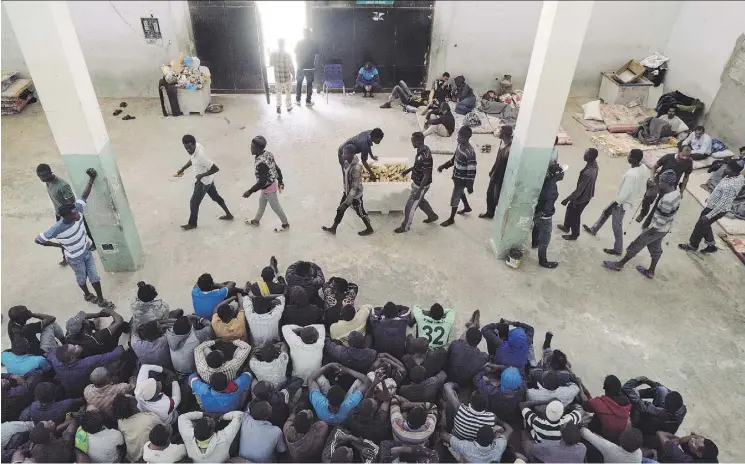  ?? LORENZO TUGNOLI/THE WASHINGTON POST ?? Inmates are given only a 15-cm loaf of bread for lunch at the al-Nasr detention centre for migrants in Zawiyah. Dinner is a plate of macaroni.