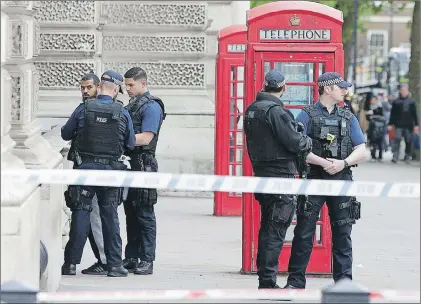  ?? AP PHOTO ?? Police officers talk to a man at the scene after a person was arrested following an incident in Whitehall in London Thursday. London police arrested a man for possession of weapons Thursday near Britain’s Houses of Parliament.