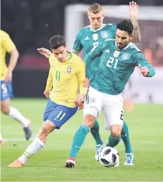  ??  ?? Germany’s Ilkay Gundogan and Toni Kroos (centre) vie for the ball with Brazil’s Philippe Coutinho during their internatio­nal friendly in Berlin. — AFP photo