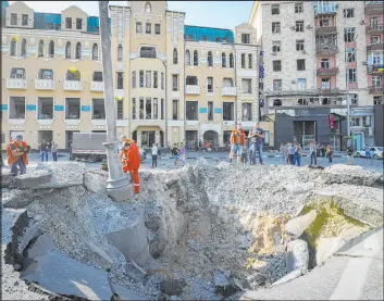  ?? Andrii Marienko The Associated Press ?? A view on Saturday of a crater in the street caused by a night Russian rocket attack, near damaged buildings in downtown Kharkiv, Ukraine.