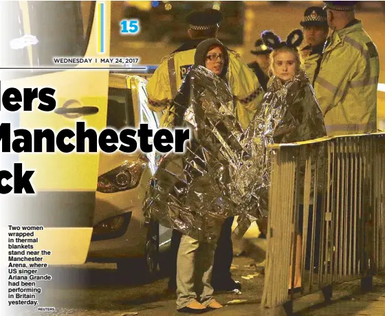  ?? REUTERS ?? Two women wrapped in thermal blankets stand near the Manchester Arena, where US singer Ariana Grande had been performing in Britain yesterday.
