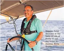  ??  ?? Skipper Peter Blunden at the helm of Life of Reilly III sailing home to Halifax, Nova Scotia.