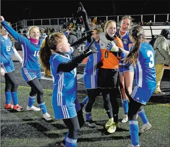  ?? SARAH GORDON/THE DAY ?? Old Lyme’s players crowd goalie Samantha Gray (0) as they celebrate Wednesday night’s 2-0 win over Northwest Catholic in the Class S girls’ soccer tournament semifinals at Xavier High in Middletown.