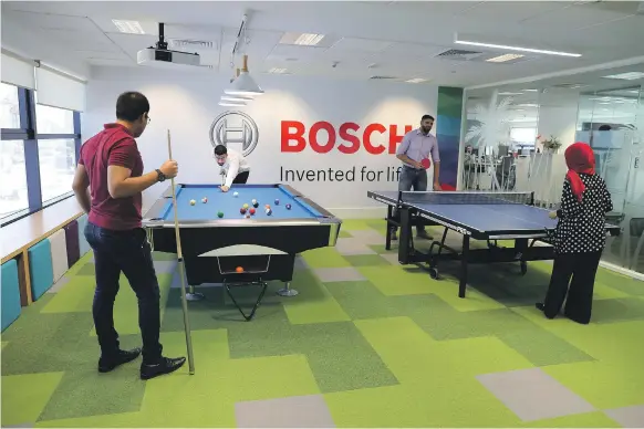  ?? Pawan Singh / The National ?? Employees play games at Bosch Middle East’s office in Dubai. More businesses are trying to improve their employees’ work-life balance