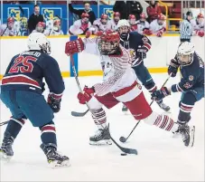  ?? JULIE JOCSAK THE ST. CATHARINES STANDARD ?? St. Catharines’ Carson Edwardson, with the puck, is defended by Lockport in Greater Ontario Junior Hockey League action Tuesday night at Jack Gatecliff Arena in St. Catharines.