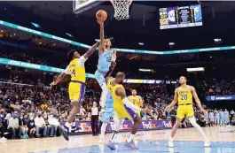  ?? — AFP photo ?? Memphis Grizzlies guard Ja Morant goes to the basket against Los Angeles Lakers’ Stanley Johnson and LeBron James at FedExForum in Memphis, Tennessee.