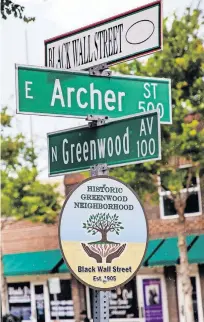  ?? LANDSBERGE­R/ THE OKLAHOMAN] ?? RIGHT: The Historic Greenwood Neighborho­od, also known as Black Wall Street, is designated on this street sign in Tulsa. [CHRIS