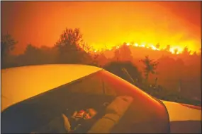  ?? (Agencia Lusa/ Nuno Andre Ferreira) ?? In this image released by World Press Photo by Nuno Andre Ferreira for Agencia Lusa, titled Forest Fire, which won third prize in the Spot News Singles category, shows a child sitting inside a car close by a forest fire in Oliveira de Frades, Portugal, on Sept. 7.