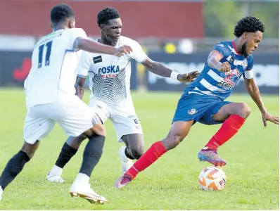  ?? RICARDO MAKYN/CHEIF PHOTO EDITOR ?? Portmore United’s Alex Marshall (right) dribbles away from Cavalier’s Christophe­r Ainsworth (left) and Ronaldo Barrett during yesterday’s Jamaica Premier League encounter at the Anthony Spaulding Sports Complex in Arnett Gardens. Portmore won 1-0.