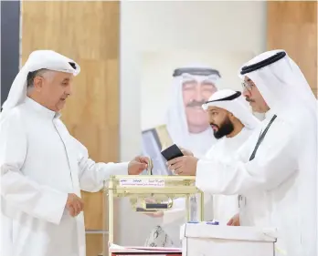  ?? — AFP ?? A Kuwaiti man casts his ballot in parliament­ary elections at a polling station in Kuwait City.