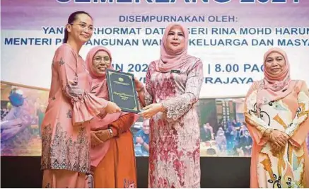  ?? (Foto BERNAMA) ?? Rina menyampaik­an anugerah kepada Hong Ling Ling dari JKM Sarawak pada majlis Anugerah Perkhidmat­an Cemerlang 2021 di Putrajaya, semalam.